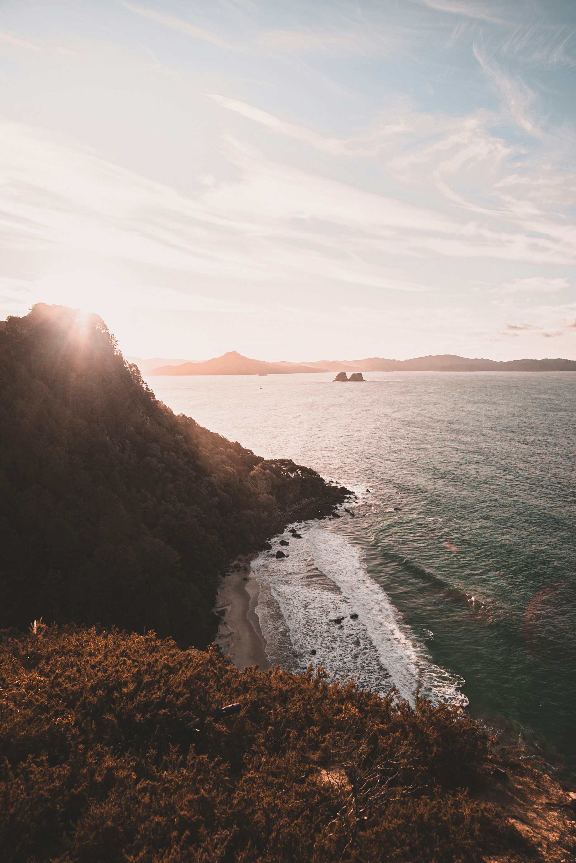 person standing on rock formation near body of water during daytime